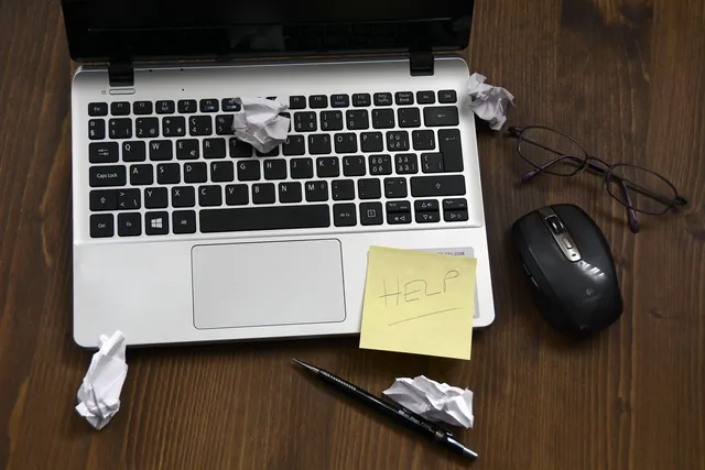 Laptop with a note asking for help, representing post-delivery support