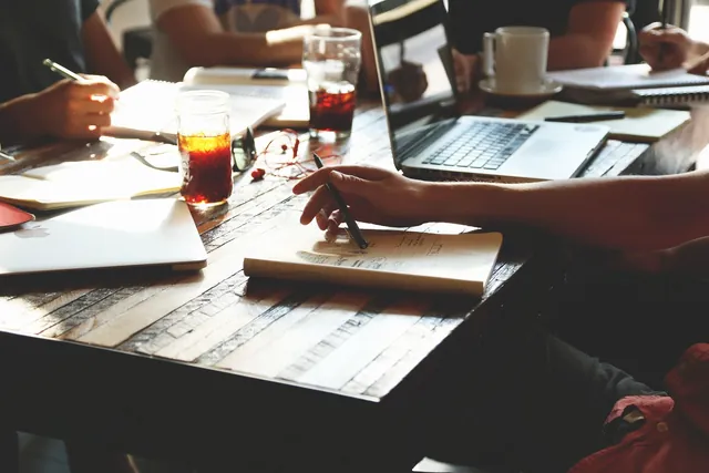 Work meeting with a laptop, notebooks and notes on the table