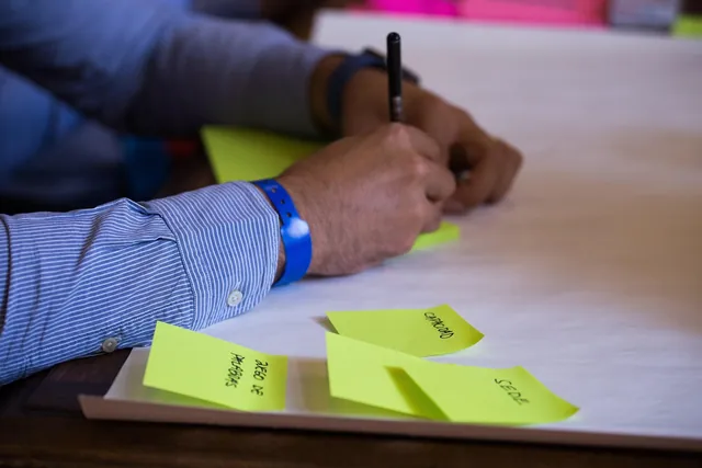 Hand writing on sticky notes to organise tasks