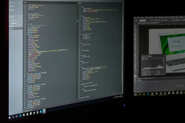 Website code being developed on two monitors